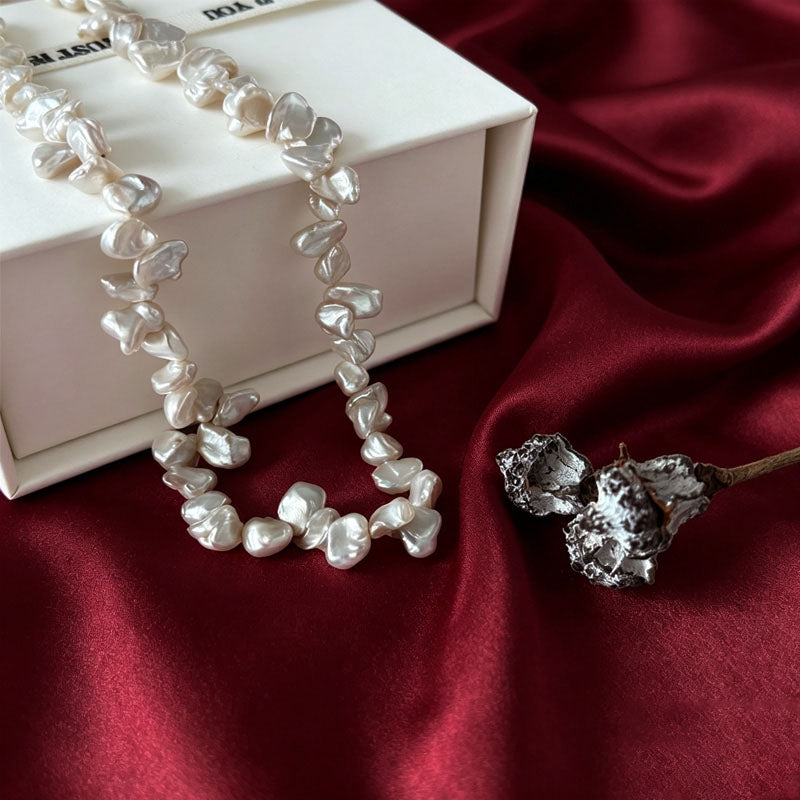 
close up of natural keshi baroque pearl irregular petal shape and soft rainbow luster on Loxun necklace
