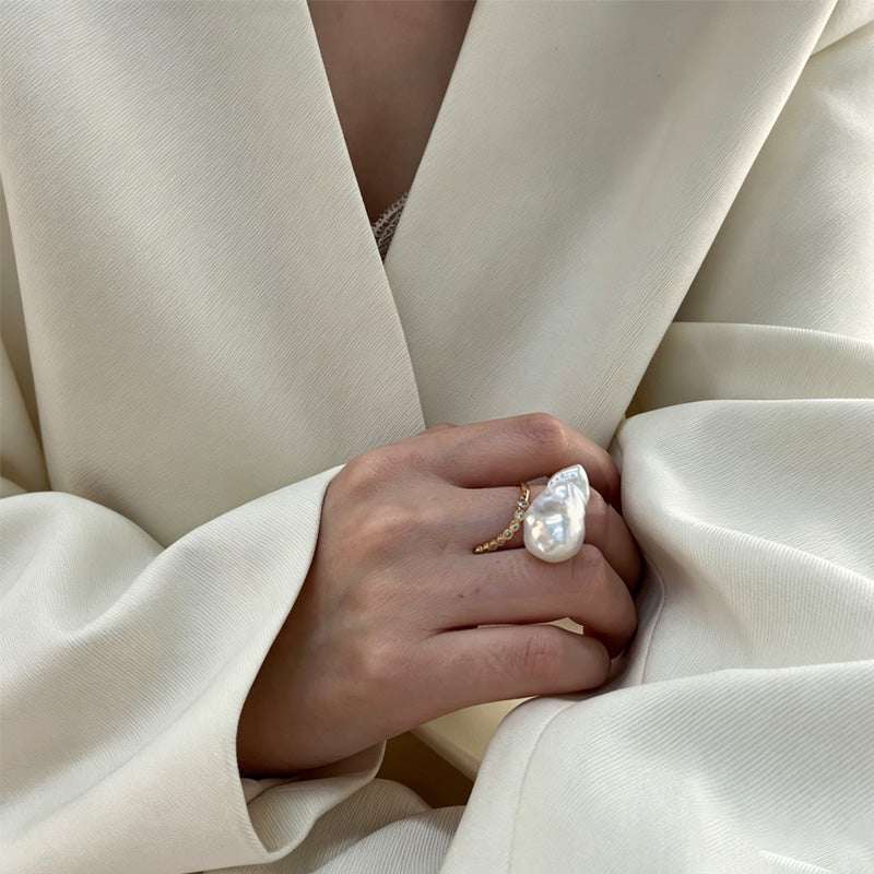 woman wearing Loxun baroque pearl ring on finger cold tone lariat stacking with gold rings