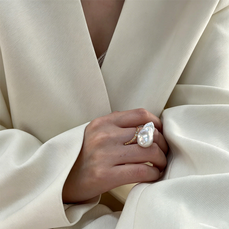 woman wearing Loxun baroque pearl ring on finger cold tone lariat stacking with gold rings