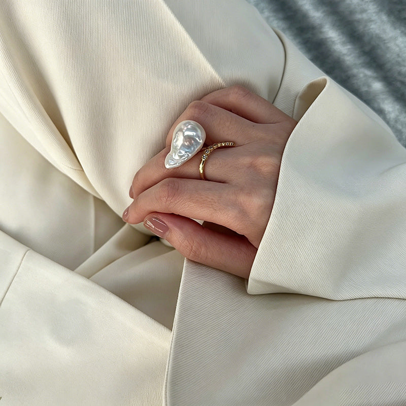 woman wearing Loxun baroque pearl ring on finger cold tone lariat stacking with gold rings
