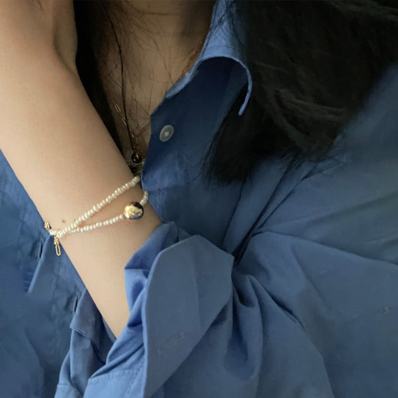 woman wearing Loxun gold ball pearl bracelet on wrist adjustable 18k gold plated sterling silver